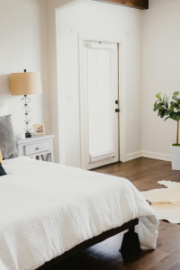 A neatly made bed and an organized nightstand